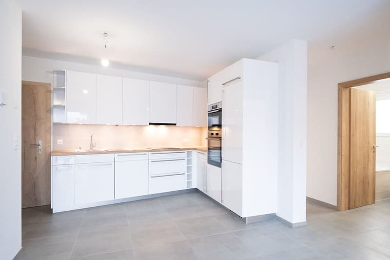 modern kitchen, white cabinets, tiled floor, wooden countertops, built-in oven, sink with faucet, dishwasher, washing machine