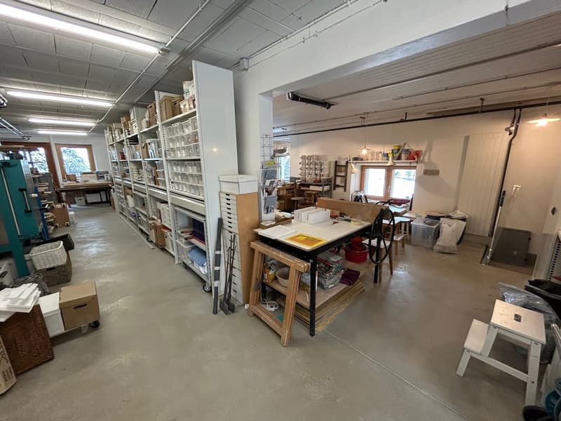 Storage room with shelves, boxes, a desk, a window with a view, and tools