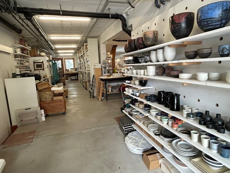 Interior of a store with white shelves filled with white ceramic ware and bowls