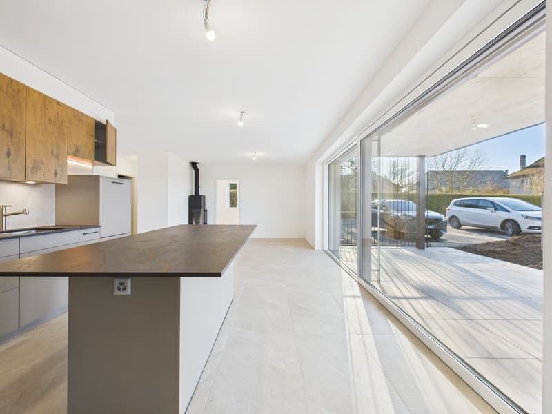 modern kitchen with island, wooden cabinetry, granite countertop, stainless steel sink, large glass windows, polished floor