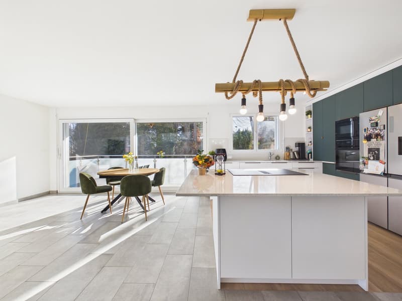 modern kitchen, white countertops, central island, modern chandelier, dining table, green chairs, large glass doors, terrace view
