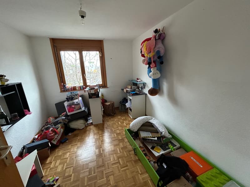 room with wooden floor, white walls, window, shelves, storage boxes, toys, and a desk