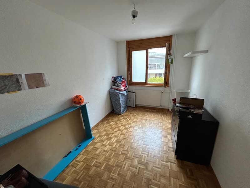 empty room, wooden floor, white walls, window, radiator, shelf, blue table, black cabinet