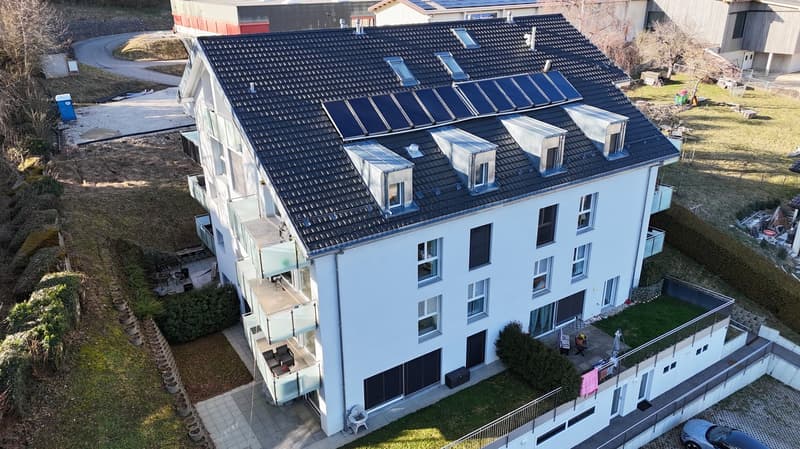 2 story house, black roof, white exterior, solar panels, balconies, several windows