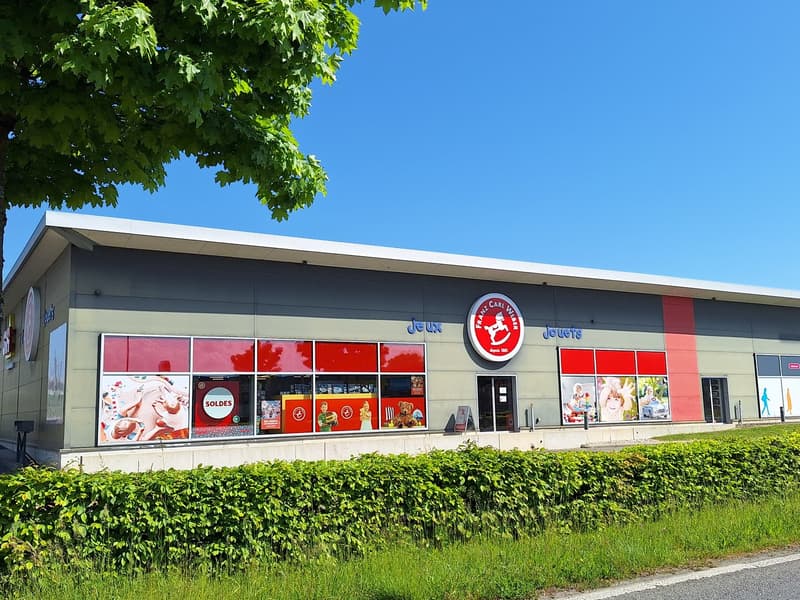 The image shows a large retail store with a red and white color scheme. The store has large windows displaying various products and sales promotions. The store's name is 'Rance Carl Weber' and it appears to sell toys and other children's products.