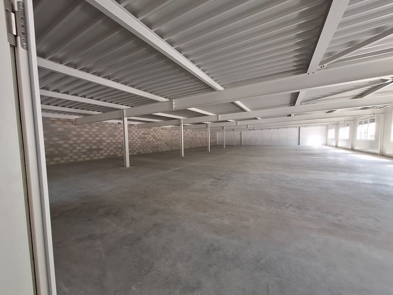 empty room with metallic ceiling and floor, brick walls at end, no furniture