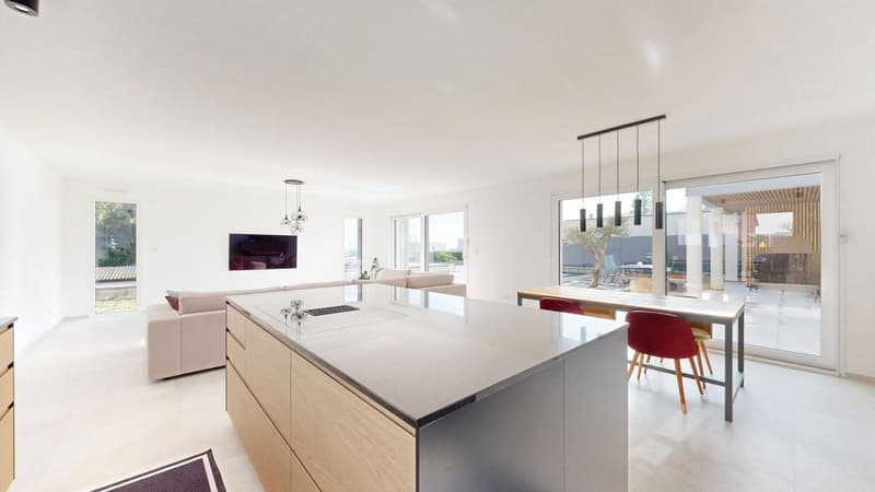 modern kitchen with island, large windows, balcony, dining table, couch, TV
