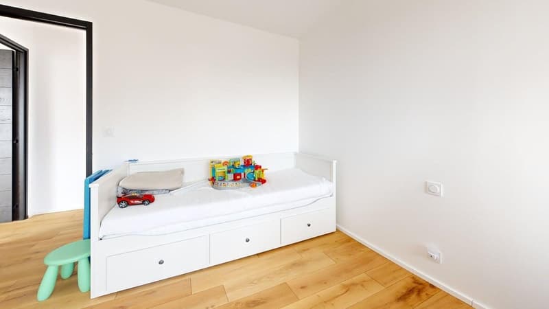 white bed with drawers, green stool, toys, white walls, wooden floor