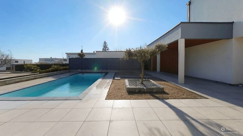 Modern building, swimming pool, tile flooring, garden area, fenced, sunlit