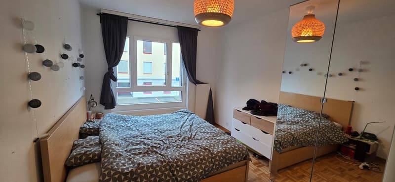 bedroom with bed, cabinet, and window with street view