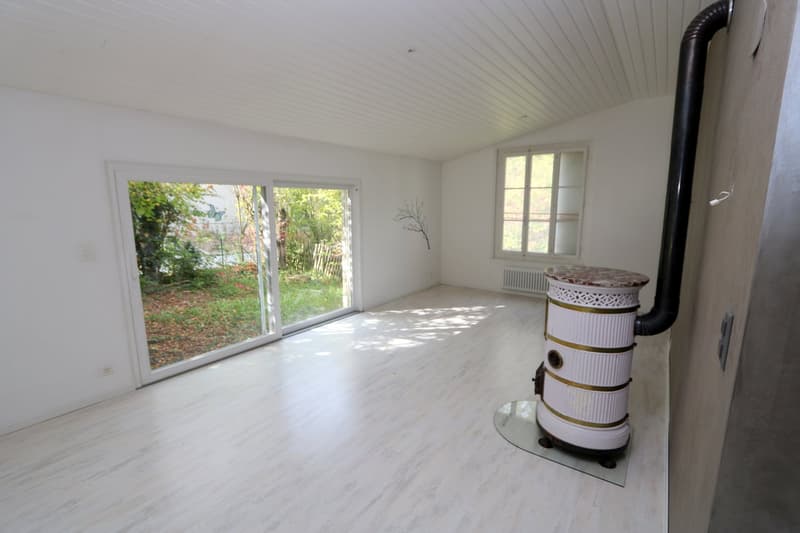 empty room, sliding glass door, fireplace, radiator, black pipe, white walls, wooden floor