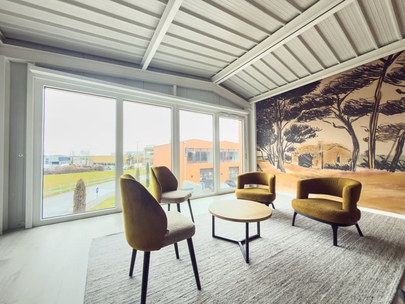 Modern room with beige furniture, wooden table, large windows, wooden walls, carpet, large artwork