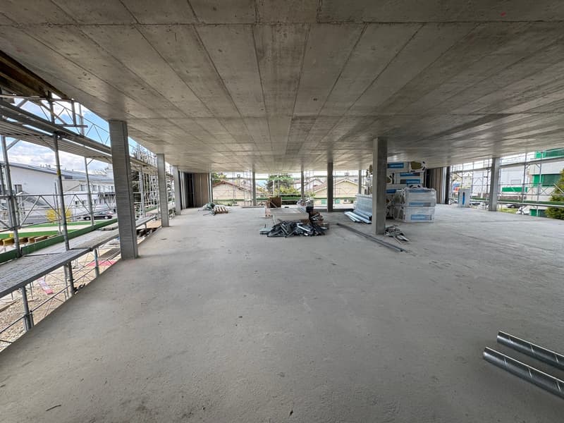 unfinished interior, concrete floor, metal scaffolding, construction materials