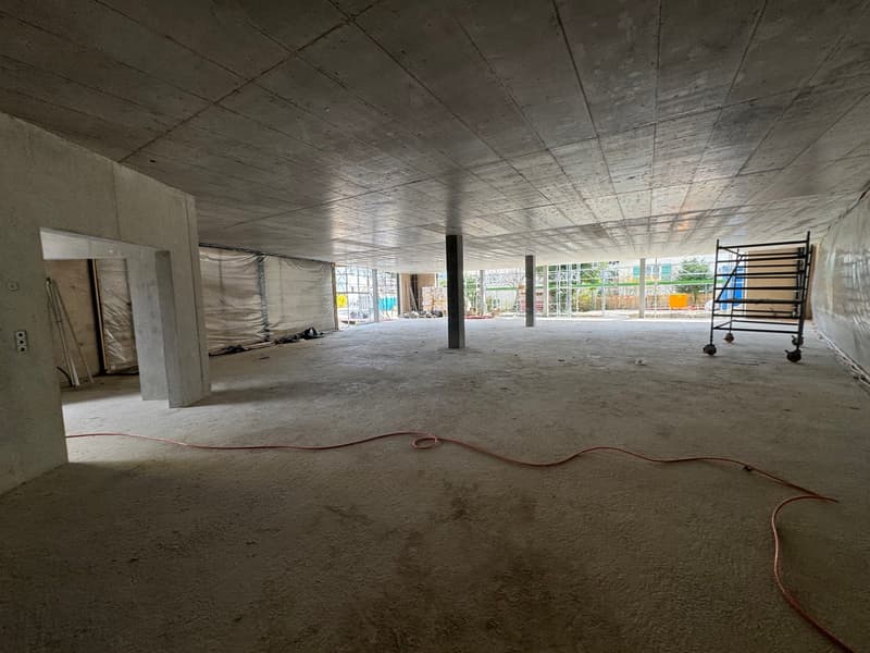 unfinished room, concrete floor, exposed beams, construction materials