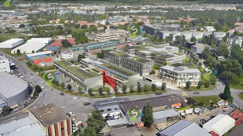 Aerial view of a urban area with multiple buildings, some under construction, surrounded by trees and greenery, with roads and cars.