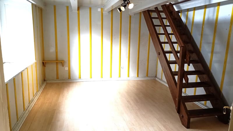 empty room, yellow and white walls, wooden floor, wooden ladder