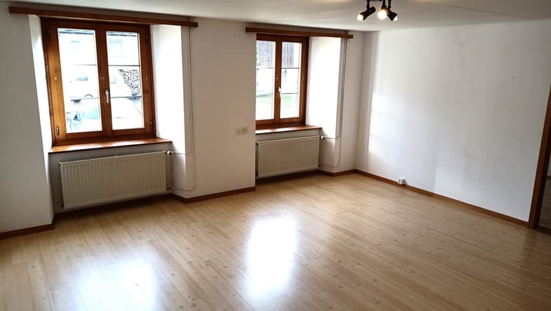 wooden floor, white walls, two windows, radiators, light fittings