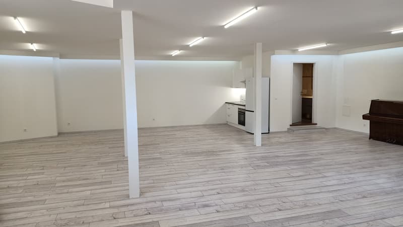 empty room, wooden flooring, kitchen area, refrigerator, wooden beams on ceiling