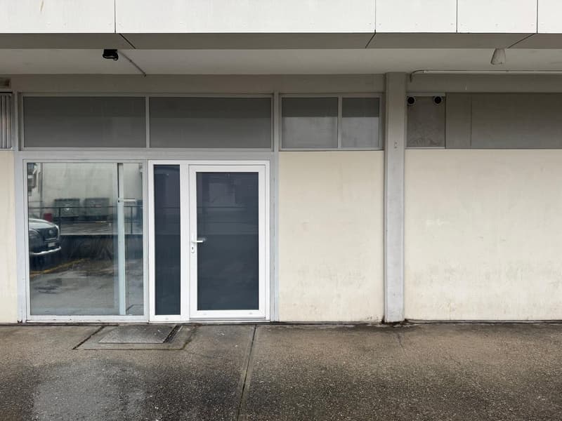 White exterior wall, two glass doors, sliding and swinging doors, square drain, entrance on concrete floor