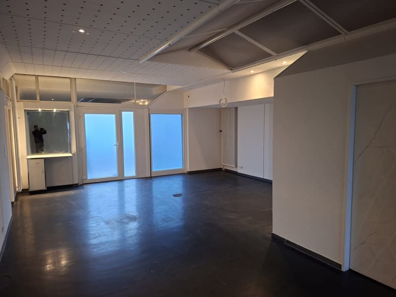 Open and large room, black floor, glass doors and windows, cabinets, air conditioning unit, spot lights