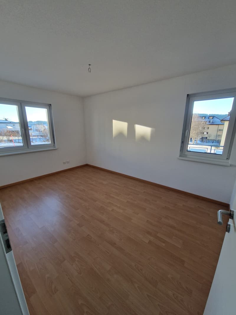empty room, wooden floor, white walls, two windows, power outlets