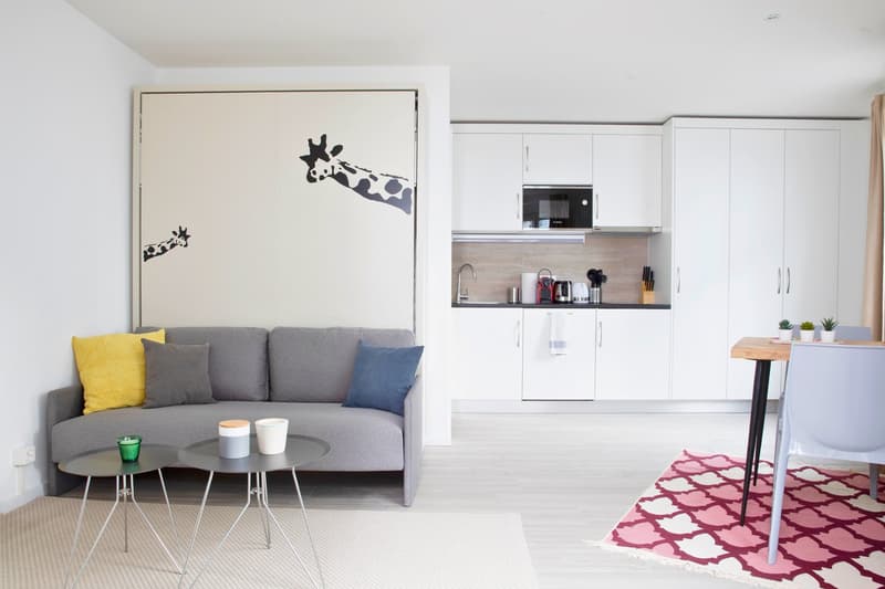 gray sofa, white floor, white kitchen, coffee table, dining table, chairs