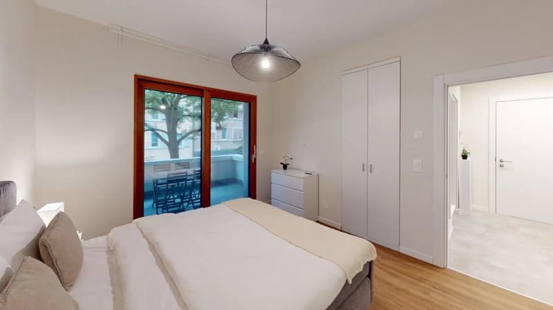 large bed, white bedding, large sliding glass doors to terrace, wooden floors, closet