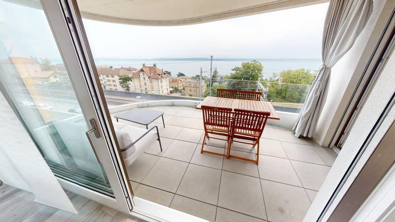tiled floor, wooden table and chairs, side table, white armchair, glass door, balcony, scenic view