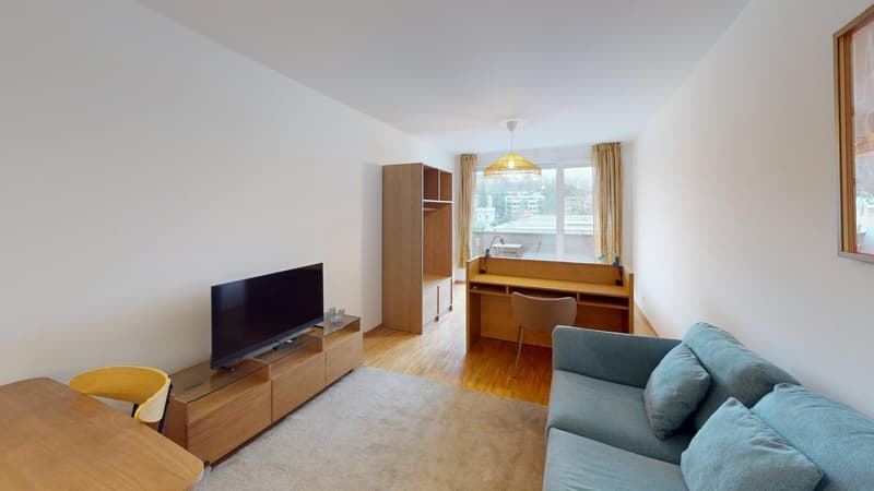 living room with a sofa, TV, wooden table, desk, and wooden flooring