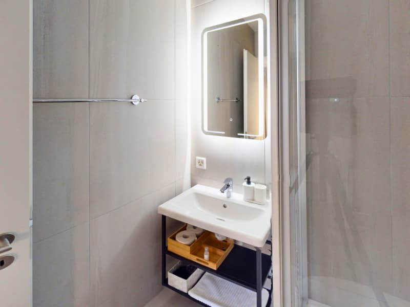 white tiles, sink, mirror, shower, storage, towels, soap