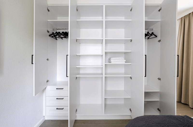 spacious walk-in closet with multiple shelves, drawers, and hanging space