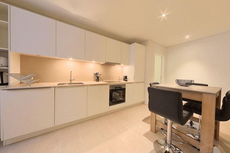 modern white cabinets, tiled floor, stainless steel sink, faucet, oven, countertop, bar stools, table