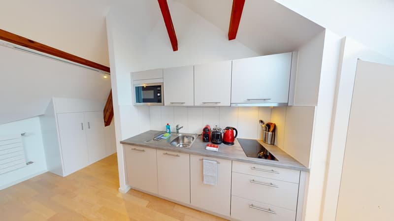 White cabinets, gray countertop, modern kitchen appliances, sink with faucet, dishwasher, wooden floor, microwave, toaster, coffee machine