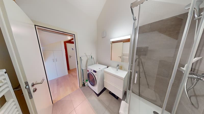tiled flooring, modern fixtures, walk-in shower, vanity with sink, washing machine, mirror, towel rack