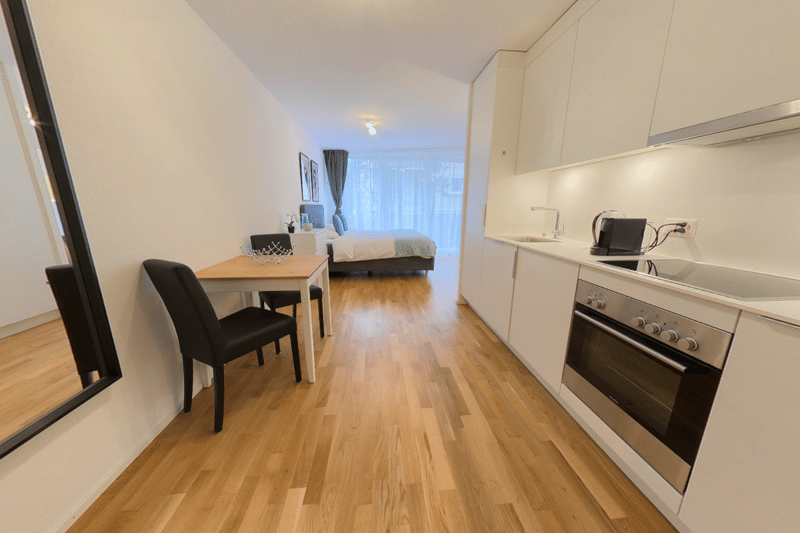 white kitchen cabinets, sink, electric oven, countertop, table with chairs, mirror
