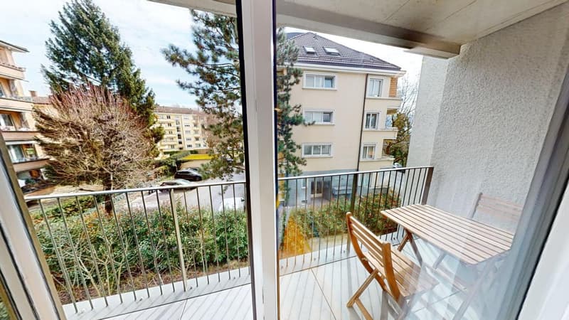 balcony with metal railing, wooden furniture, glass doors