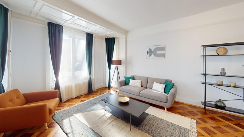 modern living room, gray couch, beige armchair, wooden flooring, natural light, large windows, radiator