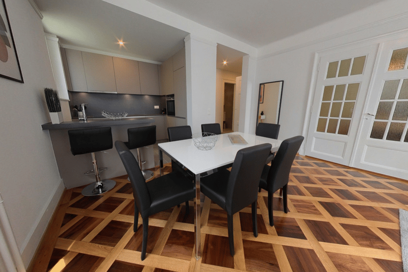 dining table, black chairs, checkered wooden floor, kitchen, plant, faucet, framed wall