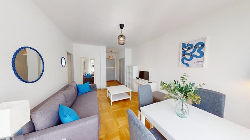 living room with couch, coffee table, dining table, chairs, monitor, mirror, lamp