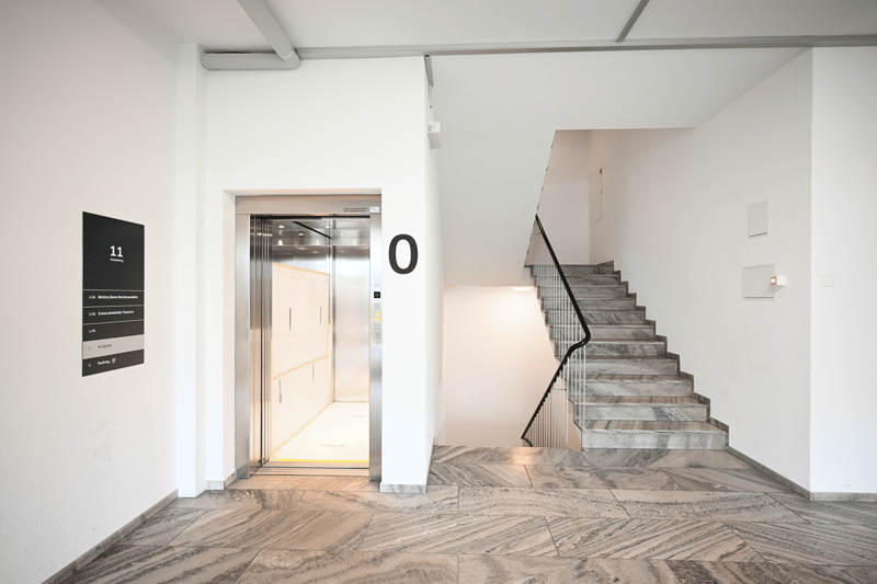 Entrance area with marble floors, elevator, stairs leading up to another floor