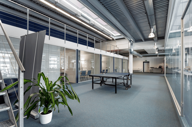 Table tennis table, plants, glass walls, ceiling lights, empty room