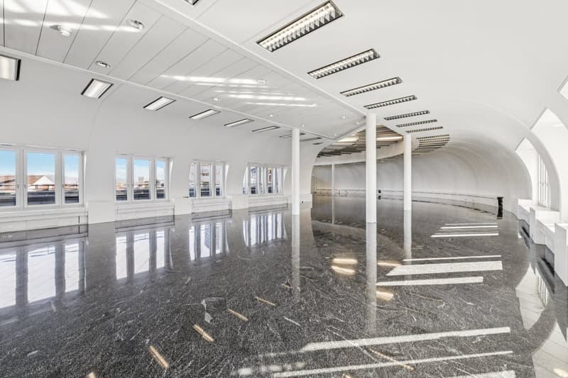 Wide room, high ceiling, white walls, marble floor, multiple large windows