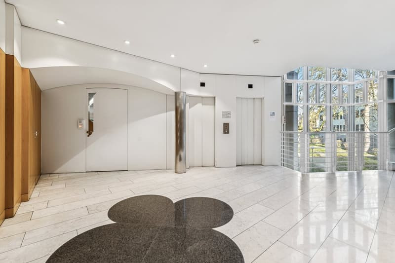 elevator, marble flooring, large windows, railing, shiny pillar, decorative tiles, wooden cabinet
