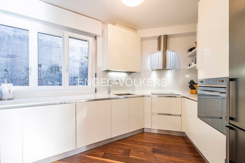 white cabinets, stainless steel appliances, double window, wooden floor