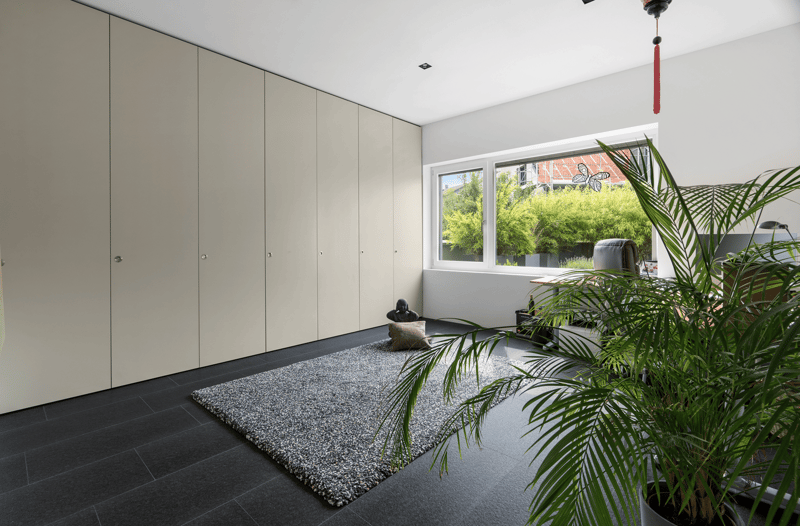 a room with a tiled floor, gray closets, gray rug, and large window