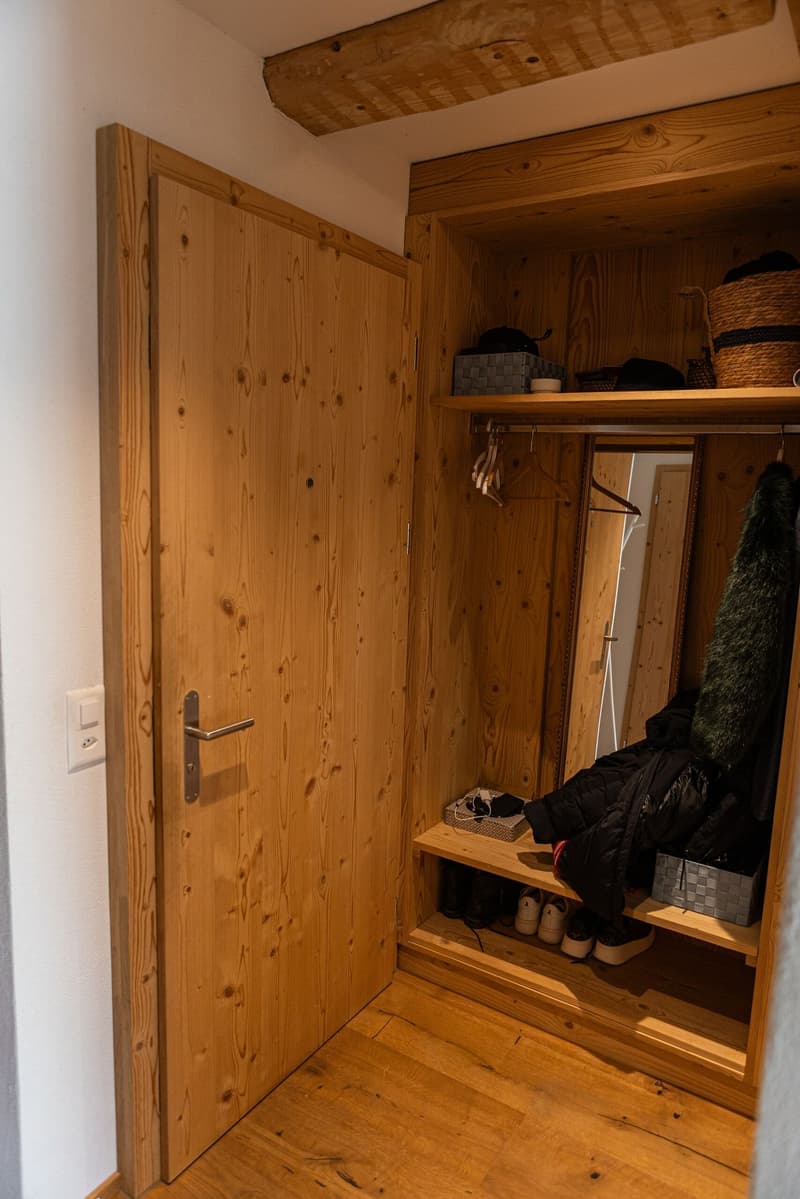 Large wooden wardrobe, wooden flooring, with storage space, shelves, hanging mirror and coat hooks