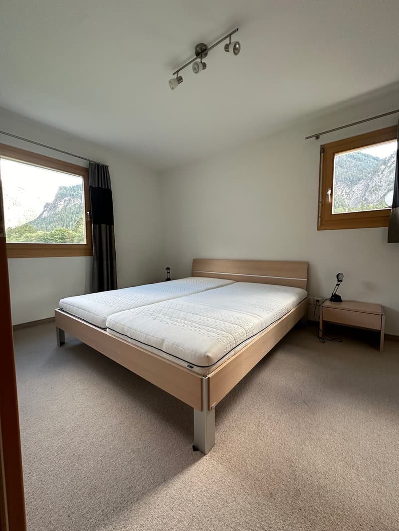 empty room, twin beds, wooden bedside table, 2 windows, view of mountains