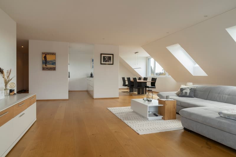 white walls, wooden floors, gray couch, white coffee table, rug, windows