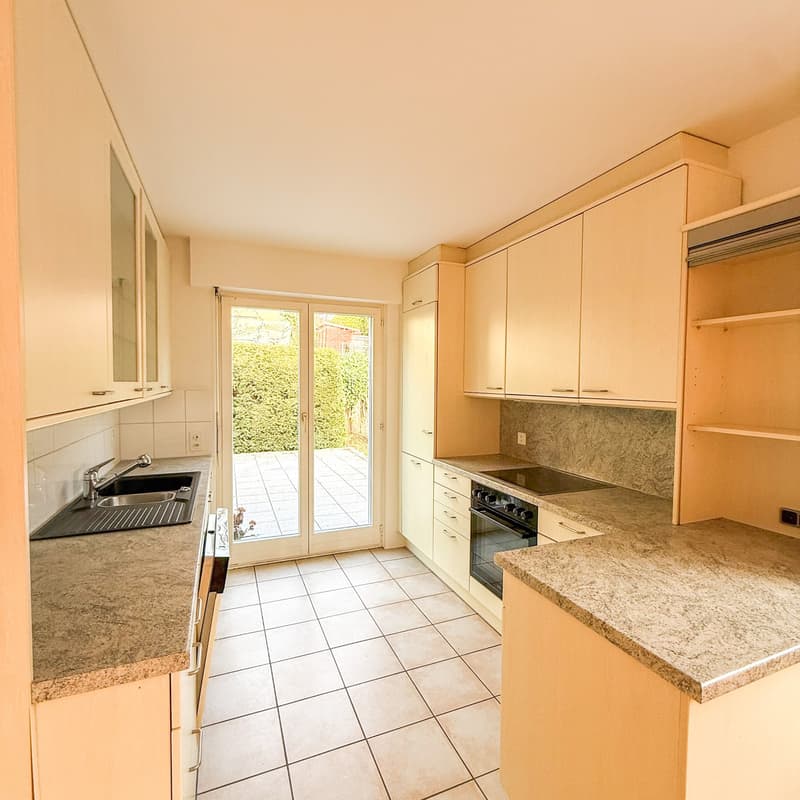 Modern kitchen with granite countertops, glass doors, oven, dishwasher, cabinets, and washing machine