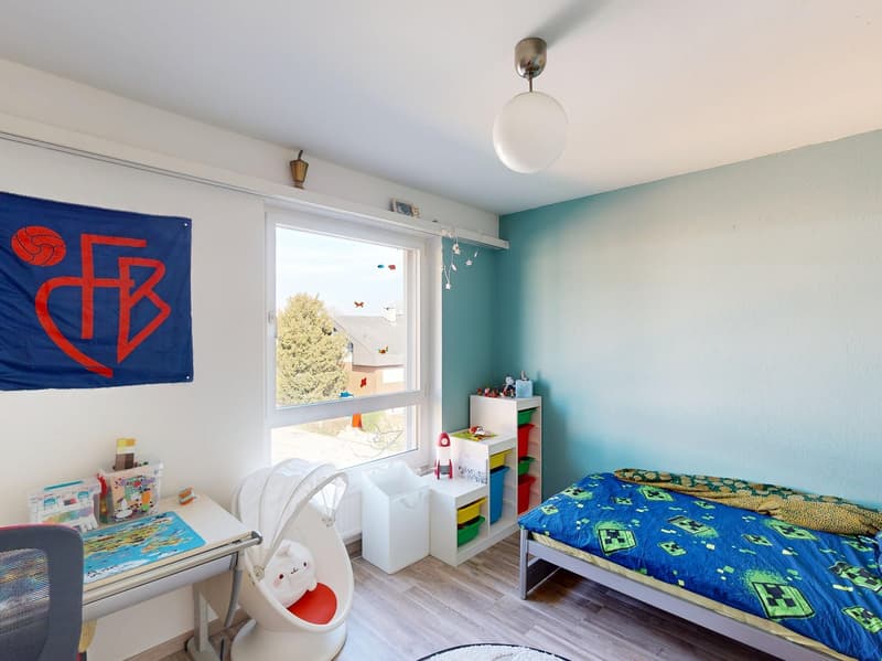 bedroom with bed, desk, storage boxes, window, lamp, decorative items